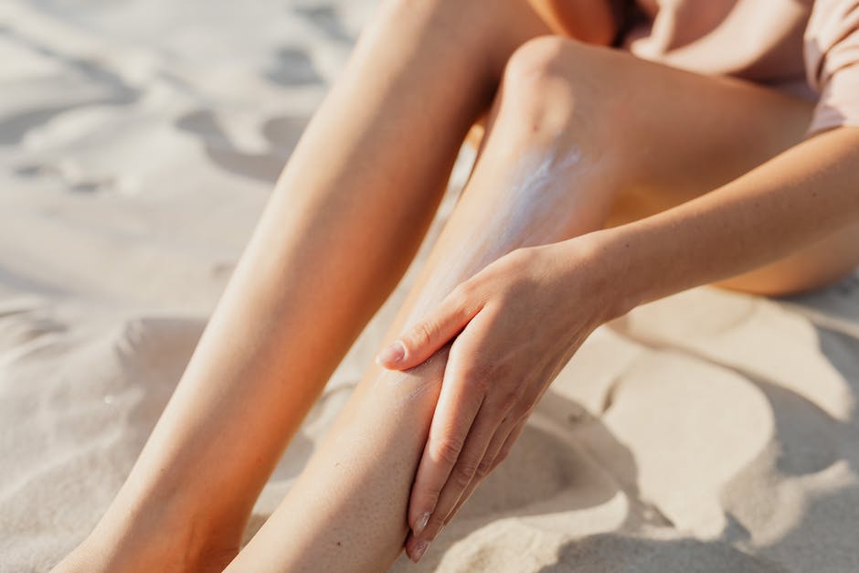 Illustration of a person applying sunscreen on their skin with sun in the background.