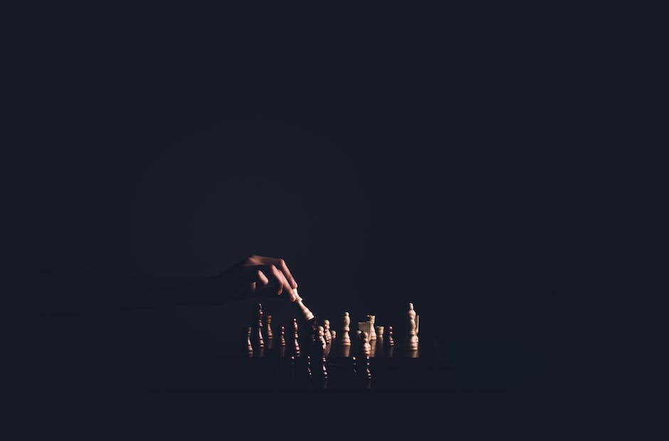 A person holding chess pieces with a chessboard in the background