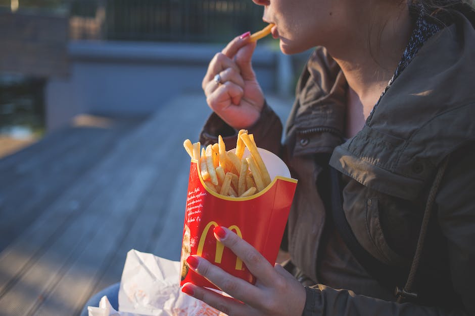 A famous pop singer sitting down with a McDonald's meal, looking happy and enjoying the food.