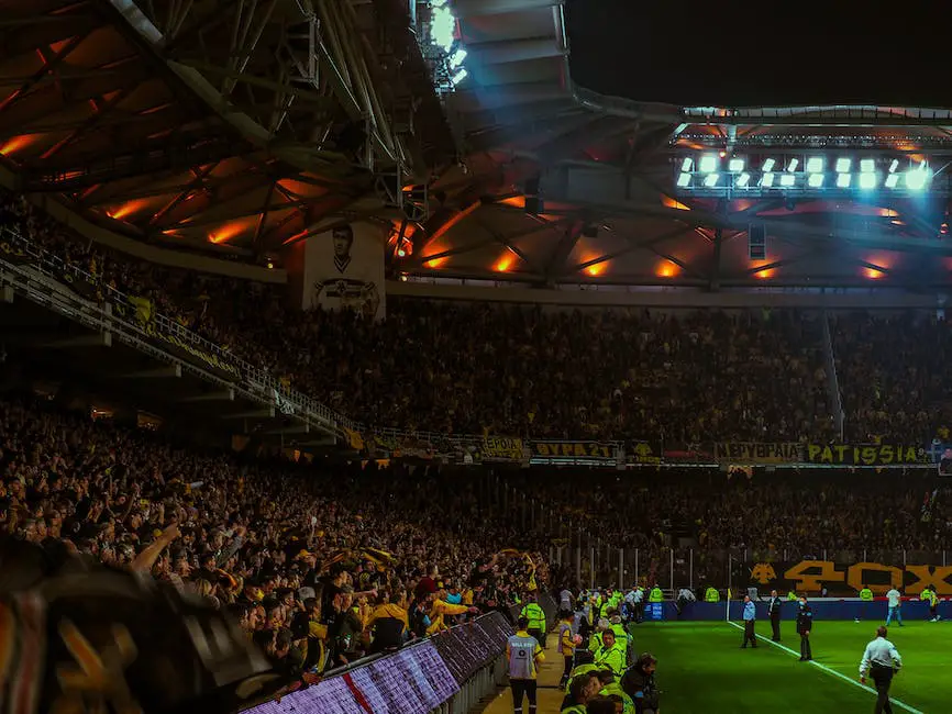 A group of football fans gathered around a table, cheering on their team while they enjoy themed decorations and food.