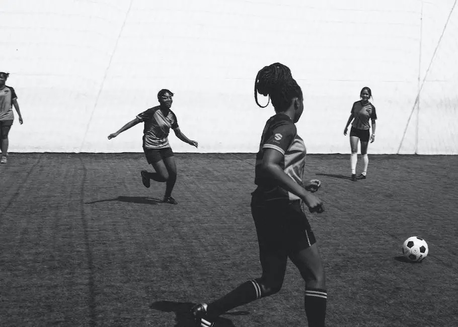 A group of women playing soccer on a green turf field at a stadium